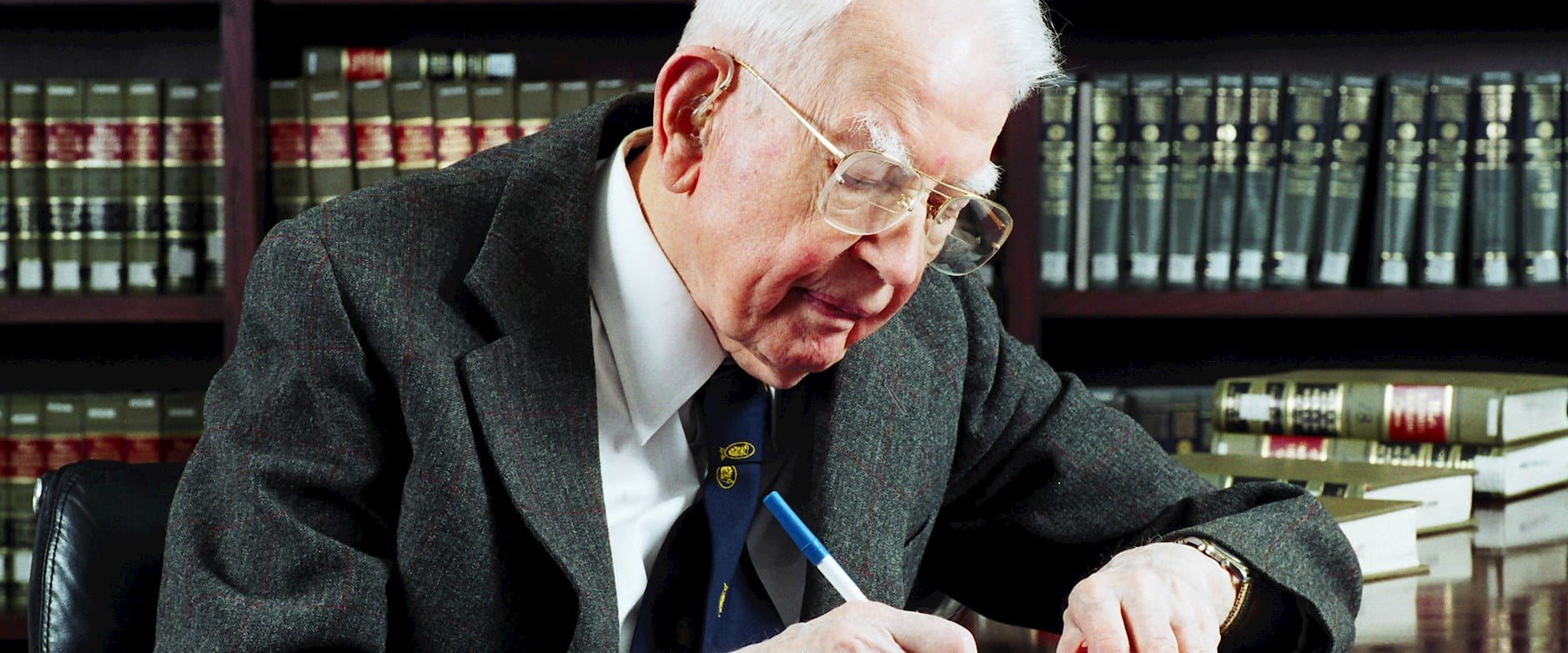 Ronald Coase writing in his office