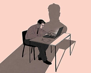 Person nervously working as looming shadow figure approaches