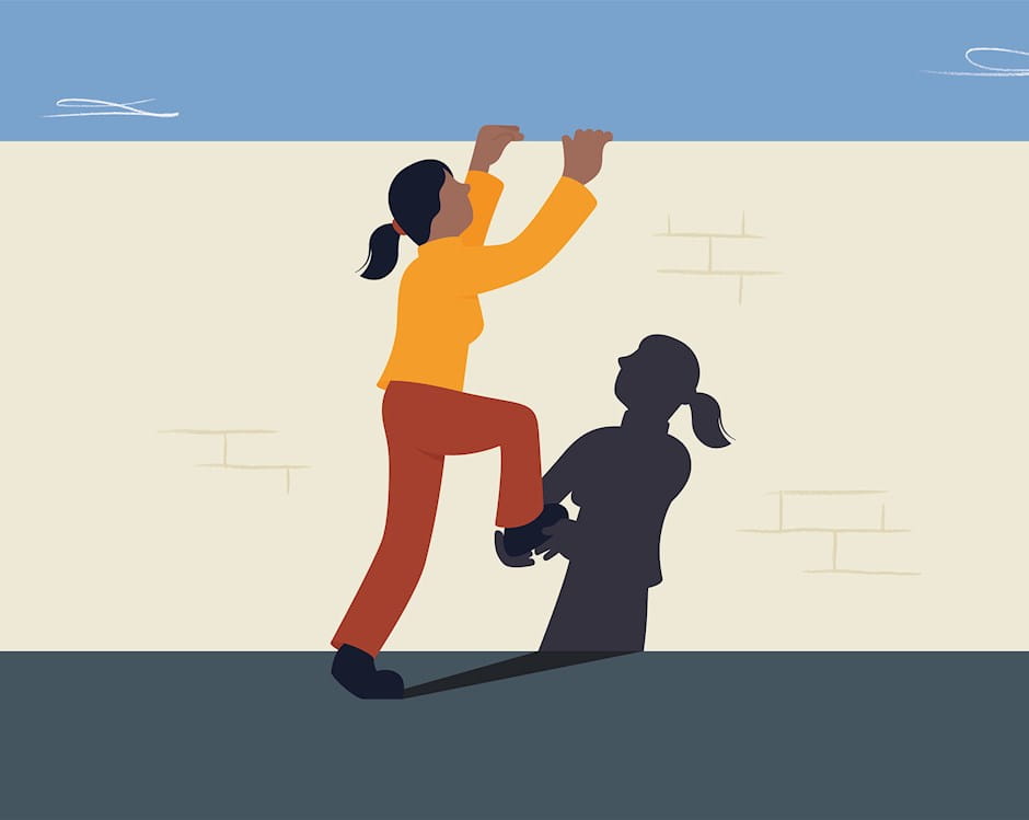 Woman climbing a wall with a boost from her shadow